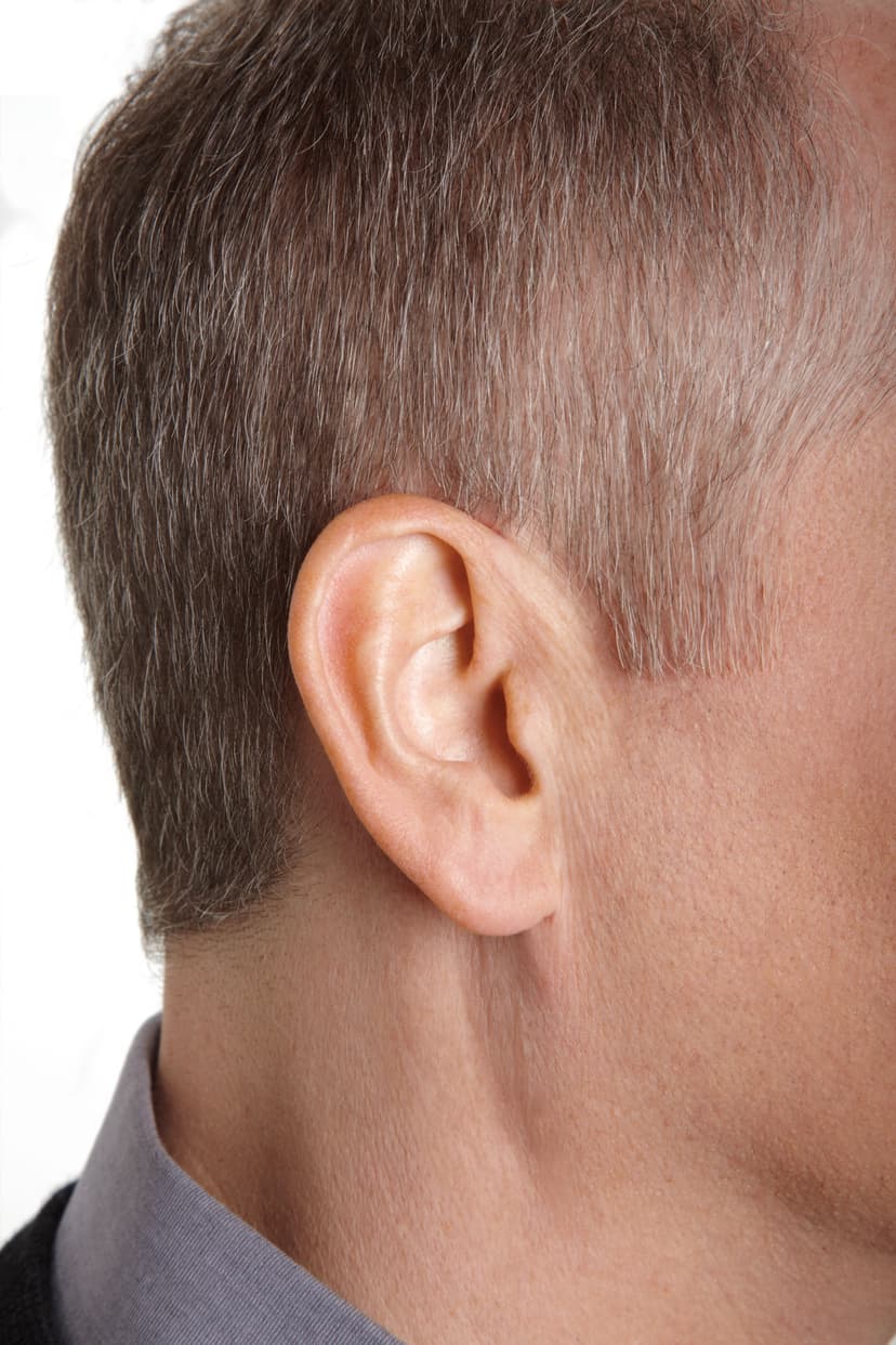 Close-up of a person's ear showing how invisible an IIC hearing aid is when worn