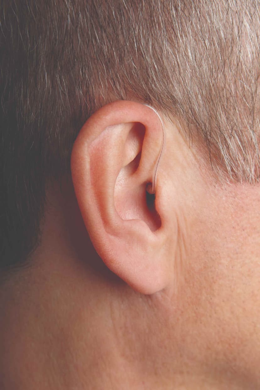 Close-up of a person's ear wearing a RIC hearing aid with a nearly invisible wire