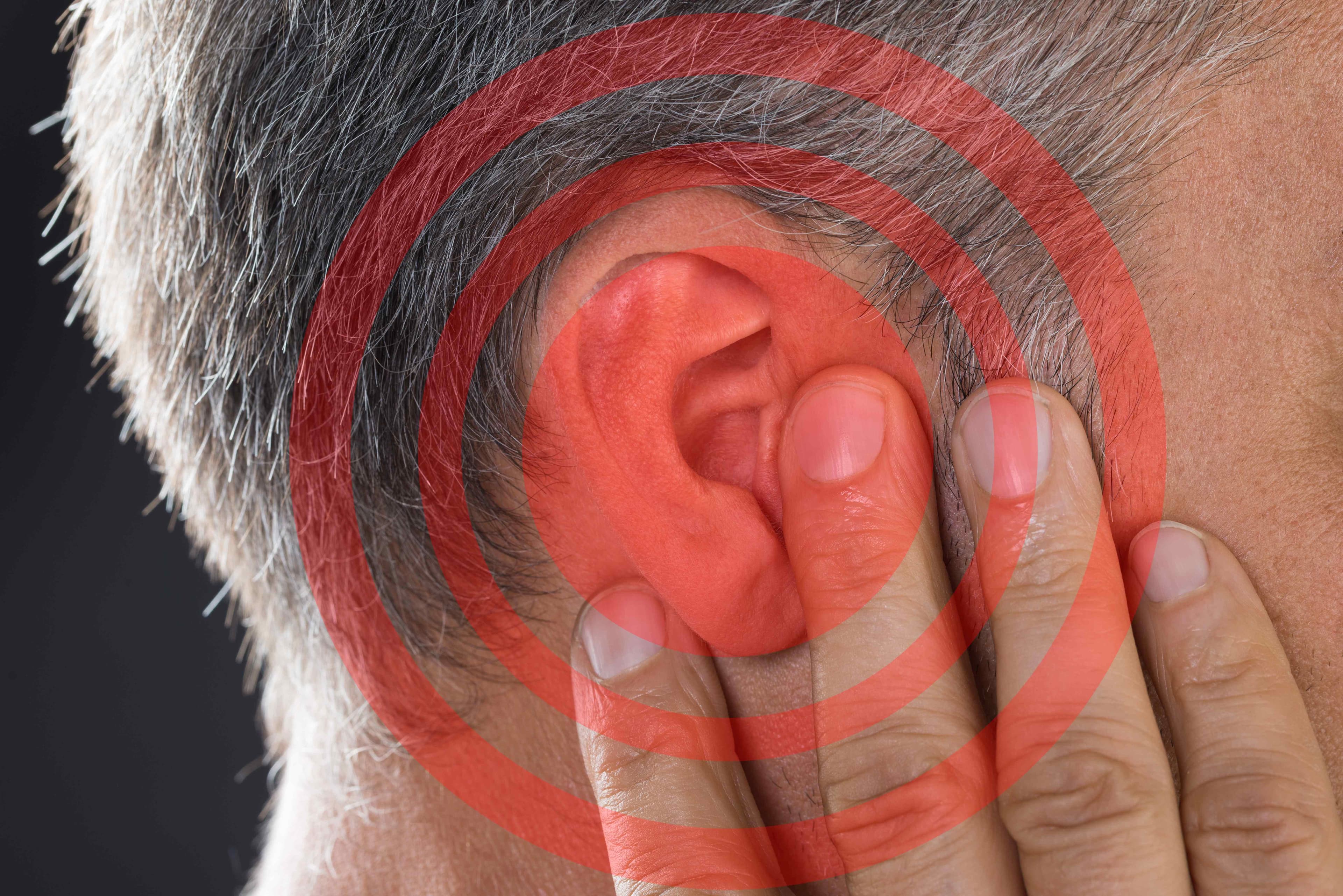 Close-up of an ear with red concentric circles illustrating tinnitus ringing