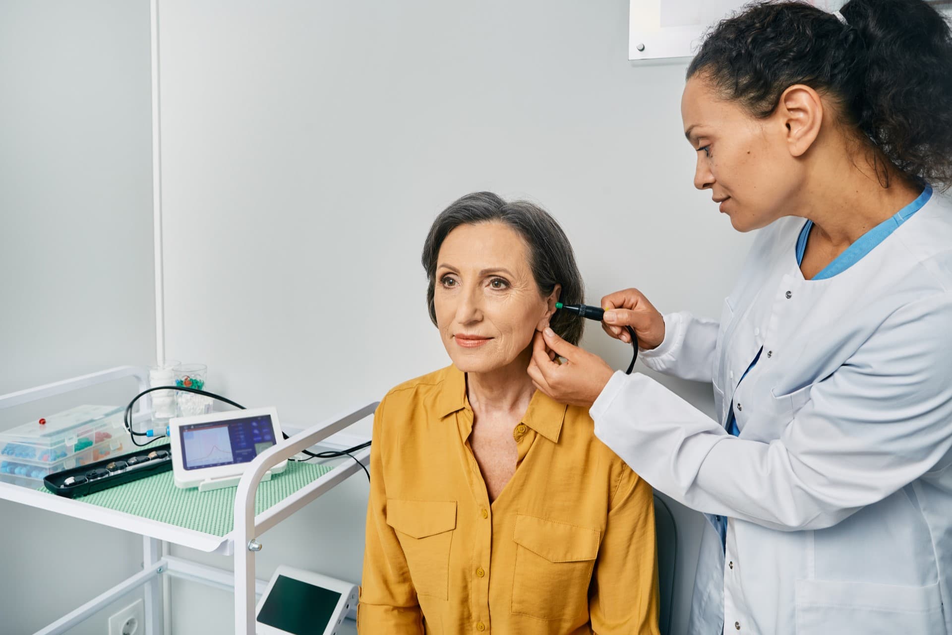 A Livingston hearing specialist performing an ear canal screening with a video otoscope